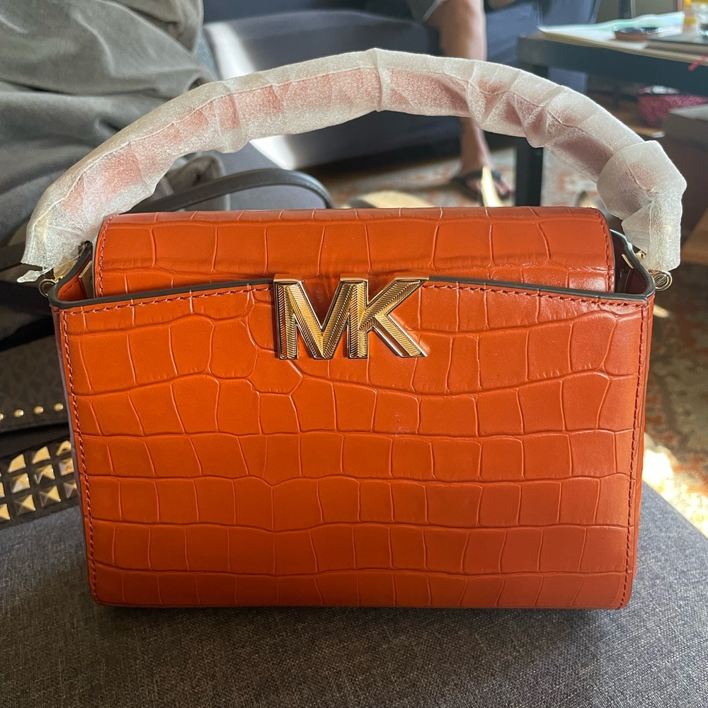 The bag is small. The brand is Michael Kors.